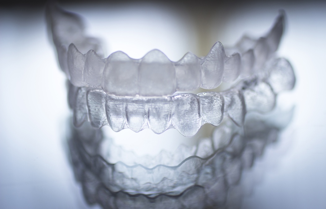 Invisible dental teeth brackets tooth aligners plastic braces retainers to straighten teeth. Orthodontic temporary removable straighteners in dental office dentists surgery clinic.Artistic color photo in creative blue tones. ** Note: Soft Focus at 100%,